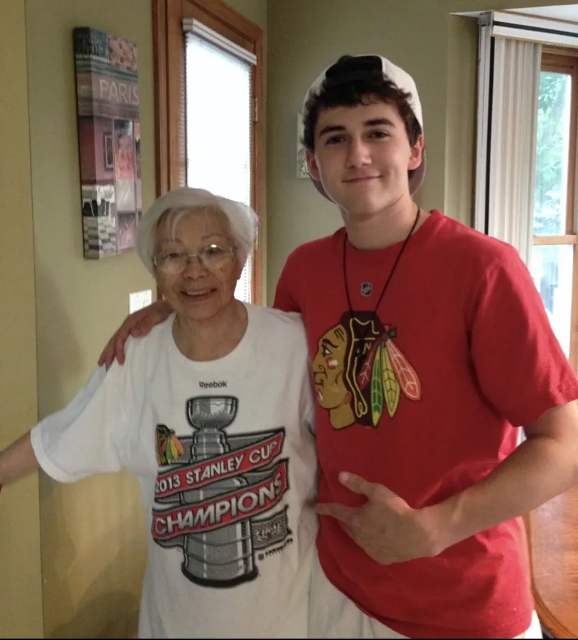 Maxim Healthcare Recruiter Matthew Morrow, who is a teen in this photo, wearing a red Tshirt. He has his arm around Shikibu Ikoma, an older woman wearing a Stanley Cup Champions T-shirt that is too big for her. They are both smiling.